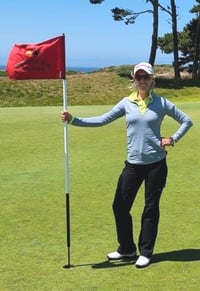 Tasha Dannenbring holding flag on golf course